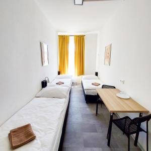 プラハにあるPractical room near the main station H3のベッド2台と木製テーブルが備わる客室です。