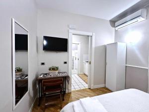a bedroom with a table and a television on the wall at La Dimoraga in Chiubbica