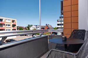 a table and chairs on a balcony with a view at Das Windhuk in Westerland (Sylt)