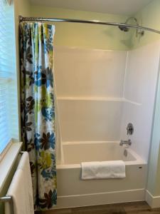a bathroom with a tub and a shower curtain at Wellington House in Nanaimo