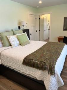 a bedroom with a large bed with green pillows at Wellington House in Nanaimo