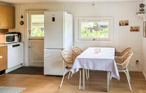 a kitchen with a table with chairs and a refrigerator at Gorgeous Home In Gilleleje With Wifi in Gilleleje