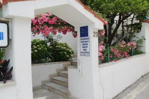 een trap met roze bloemen in een deuropening bij Adria Apartments in Podgora