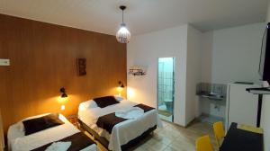 a hotel room with two beds and a television at Pousada Solar Encanto do Marajó in Soure