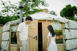 a man and a woman standing in front of a yurt at Glamping Il Rifugio dei Marsi in Ascoli Piceno