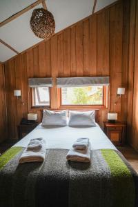 sypialnia z łóżkiem i dwoma ręcznikami na nim w obiekcie Alto Melimoyu Hotel & Patagonia w mieście La Junta