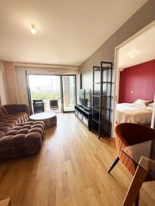 un salon avec un lit et un canapé dans l'établissement Charme Parisien neuf et cosy, à Paris