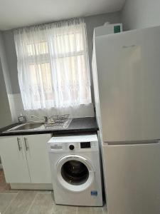 a washing machine in a kitchen next to a sink at One Bedroom Apartment Near Heathrow Airport & London in Hayes +5 photos