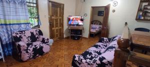 圣克里斯托瓦尔Quinta Cypress - Jardín, Wi-Fi- & BBQ - Eventos y Fiestas Privadas的客厅里有一张沙发、一张床和一台电视