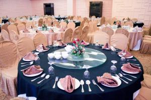 a banquet hall with tables and chairs with plates and utensils at Manila Grand Opera Hotel in Manila