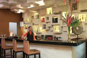 a man standing at a bar in a restaurant at Manila Grand Opera Hotel in Manila