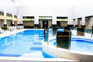 a large swimming pool with blue water in a building at Manila Grand Opera Hotel in Manila