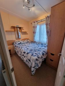 フランボローにあるThornwick bay Velvet Vale 80のベッドと窓のある小さな寝室