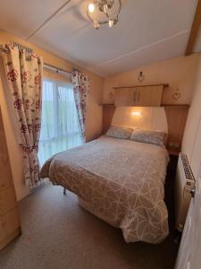 フランボローにあるThornwick bay Velvet Vale 80のベッドと大きな窓のある寝室 +8枚の写真