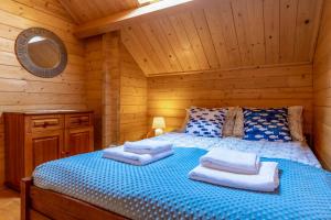 a bedroom with a bed in a log cabin at Domki Piaskowy Raj in Gąski