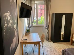 a living room with a table and a tv on the wall at BERNOCCHI ROMA APARTMENT, difronte metropolitana in Acilia