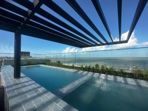 a swimming pool with a view of the ocean at Neo Duos #505 - Intermares por Carpediem in Ilha da Restinga