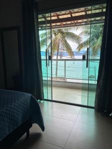 a bedroom with a bed and a view of the ocean at Encanto do Mar in Praia de Araçatiba