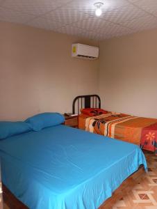 um quarto com duas camas e um ar condicionado em Hostal M&M em Los Algarrobos