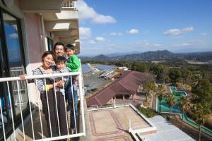 Eine Familie steht auf dem Balkon eines Gebäudes in der Unterkunft Hotel Sekia in Sekimachi + 15 Fotos