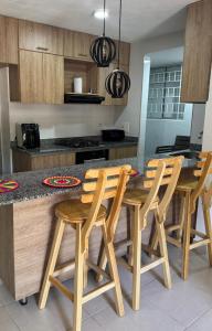 Estación El SaltoApto Santa Marta 5 minutes from the beach, pozos colorados, sazue, irotama, tayrona, playa, bello horizonte, mar的厨房配有木桌和四把椅子