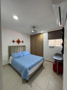 Estación El SaltoApto Santa Marta 5 minutes from the beach, pozos colorados, sazue, irotama, tayrona, playa, bello horizonte, mar的卧室里有一张床和一张书桌