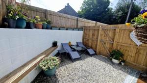 un patio con 2 sedie e una recinzione con piante in vaso di North Cornwall 2-Bed Detached Period Cottage With Parking a Camelford Altre 14 foto