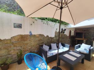 patio ze stołem, parasolem i krzesłami w obiekcie Casa O Castriño w mieście Cambados