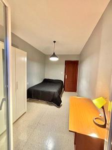 a bedroom with a bed and a wooden table at Piso amplio y luminoso ideal para pasar unos días in Madrid