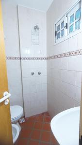 a white bathroom with a toilet and a sink at Tiny House Las Violetas en Villa Serrana La Gruta in San Andres de las Sierras +11 photos