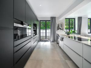 a kitchen with white walls and black cabinets at Luxury Design Loft in Hamburg
