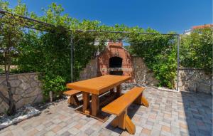 a wooden picnic table and bench in a courtyard at Apartment Maslenica in Jasenice +22 photos