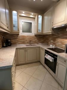 a kitchen with white cabinets and a sink at Apartment Antikyra in Antikyra