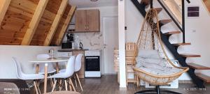 a room with a swing and a table and a kitchen at Mountain House Una in Žabljak