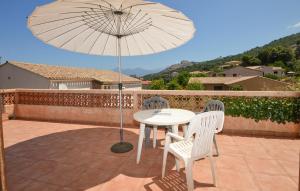 Una mesa y sillas con una sombrilla en un patio. en Cozy Apartment In Piana, en Piana
