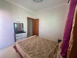 - une chambre avec un lit et une télévision dans l'établissement Appartement, à Martil