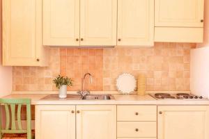 une cuisine avec des armoires blanches et un évier dans l'établissement Apartments in Pian dei Mucini - Toskana 48280, à Podere Pian Mucini