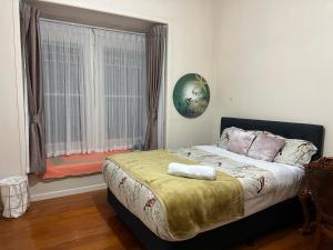 a bedroom with a large bed with a window at One Bedroom Villa Spacious Room,Amazing Location All Perks in Auckland