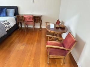 a room with a table and chairs and a bed at One Bedroom Villa Spacious Room,Amazing Location All Perks in Auckland