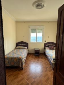 a bedroom with two beds and a window at Perfect breather in Tangier
