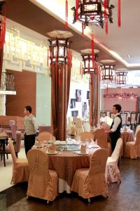 a dining room with a table and people in a restaurant at Manila Grand Opera Hotel in Manila