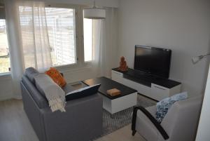 a living room with a couch and a flat screen tv at Viihtyisä pikkukoti Forssassa - Tiny cosy home in Forssa in Forssa