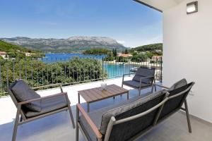 a balcony with a table and chairs and a view of the water at MaMi in Korčula