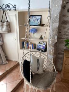 ein Schaukelstuhl mit einem Kissen in einem Zimmer in der Unterkunft Le Cordonnier d'Autrefois - 15 minutes du Puy du Fou in Mortagne-sur-Sèvre