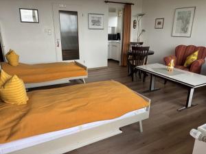 salon z dwoma łóżkami i stołem w obiekcie Tief 10 Strandkieker Meerblick 1102 w mieście Wangerland