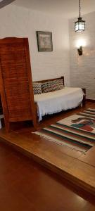 a bedroom with a bed and a rug at LA ARAUCARIA, Casa de Campo in Trenque Lauquen