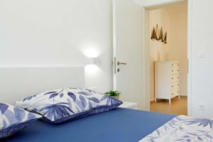 a bedroom with a bed with blue and white pillows at MaMi in Korčula