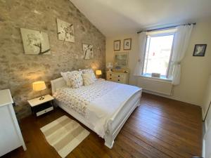 una camera da letto con un letto grande e una finestra di Le Cordonnier d'Autrefois - 15 minutes du Puy du Fou a Mortagne-sur-Sèvre