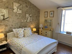 ein Schlafzimmer mit einem Bett und einem Fenster in der Unterkunft Le Cordonnier d'Autrefois - 15 minutes du Puy du Fou in Mortagne-sur-Sèvre