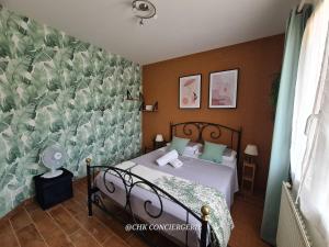 a bedroom with a bed with a green and white wallpaper at Chez Caco maison lumineuse avec jardin proche du Puy duFou in Les Herbiers
